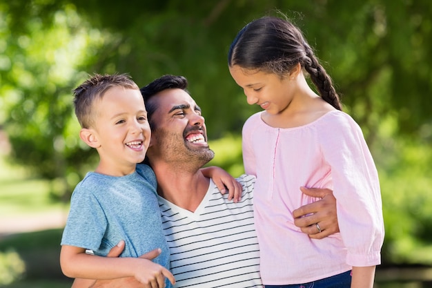 Father having fun with his son and daughter in park