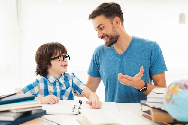 Father helps his son to do homework in school.