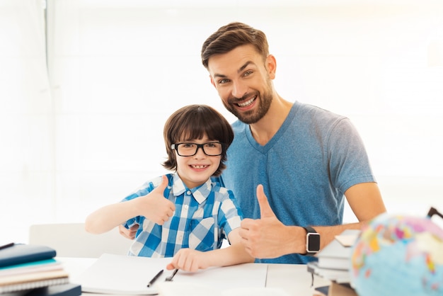 Father helps his son to do homework in school.