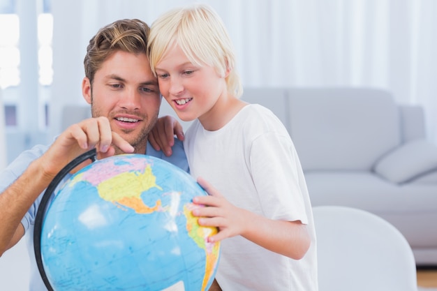 Father and his boy looking at globe