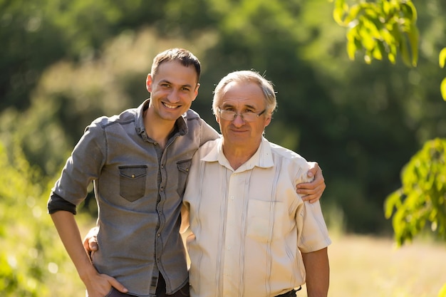 Father and his son looking at the camera in the garden