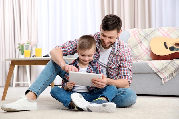 Father and his son with tablet computer at home