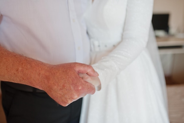 Father hold his daughter bride hand at her wedding day