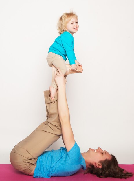 Father holding his little son on his feet, yoga, happy family