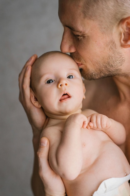 Father holding his newborn baby in hands Father kissing his baby