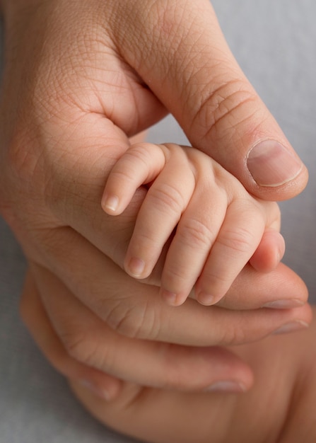 Father holding newborn baby's fingersnewborn . Hand of a newborn baby. Hands of parents and baby closeup. High quality photo