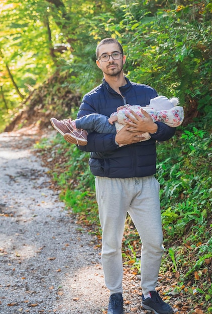 Father holding a sleeping baby in the park