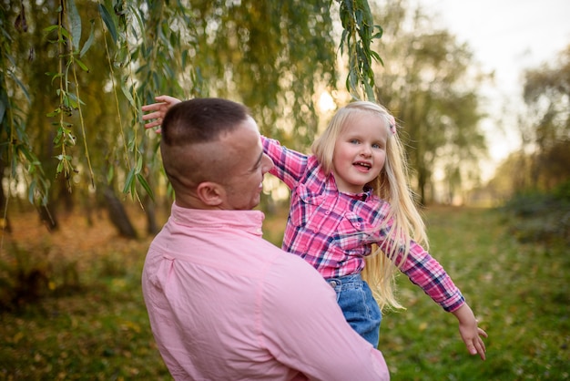 Father holds daughter in his arms.