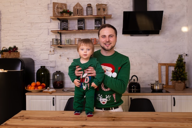 Father hugging her child in Christmas kitchen at home.