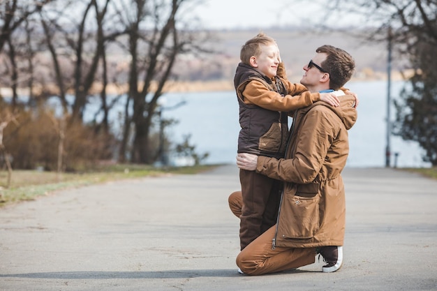 Father hugging little son outdoors