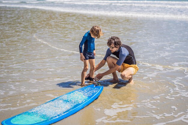 Father or instructor teaching his son how to surf in the sea on vacation or holiday travel and