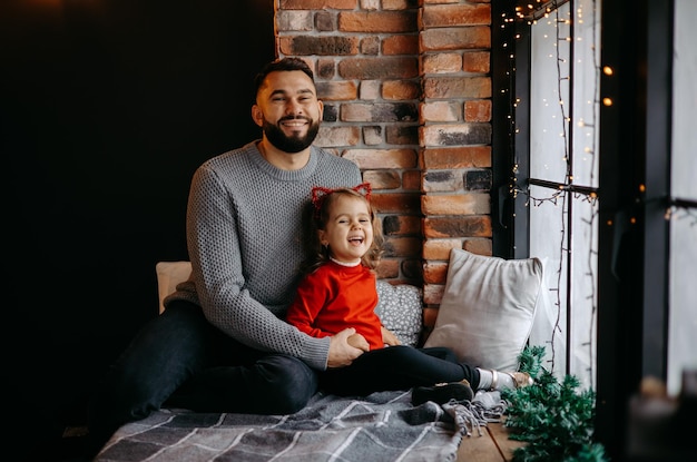 father is playing with his daughter at home on christmas eve