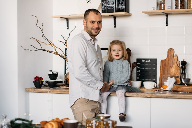 Father and little daughter in kitchen at home.