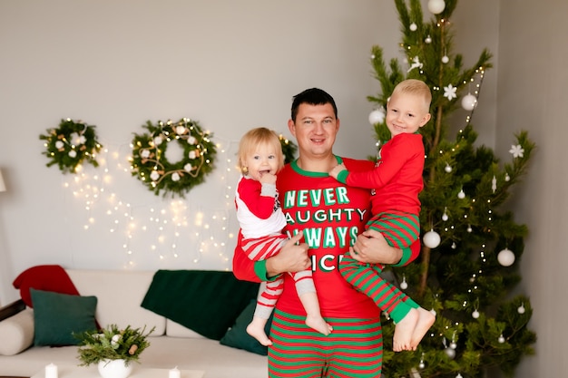 Father and little son and doughter in cozy pajamas