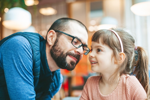 Father looking with love and tenderness at his cute little daughter