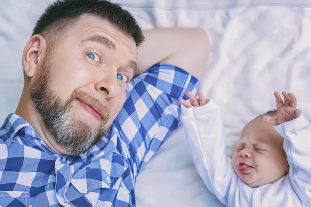 Father lying in bed with newborn baby