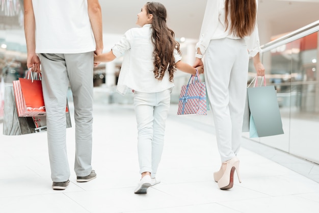 Father, mother and daughter are walking in shopping mall