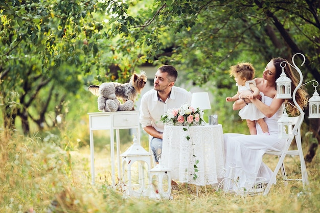 Father, mother and daughter together at the picnic in the garden