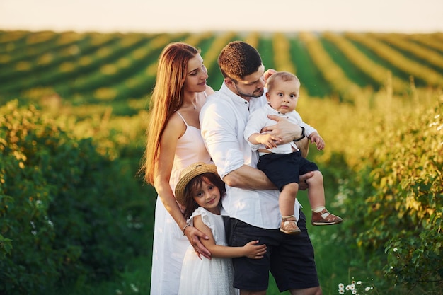 Father mother with daughter and son spending free time outdoors at sunny day time of summer