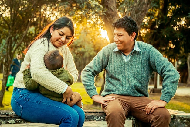 Father and mother with their little son in a park outdoors