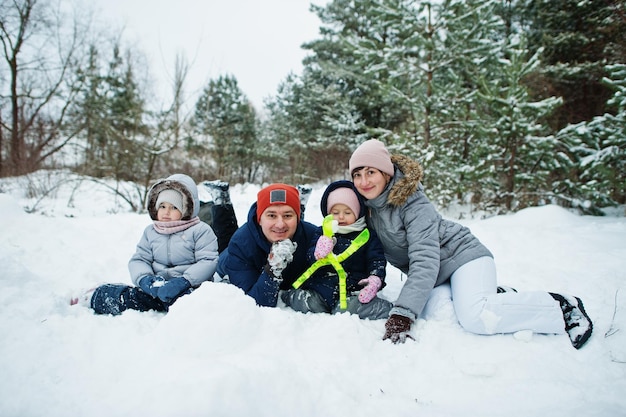 Father and mother with two daughters in winter nature Outdoors in snow