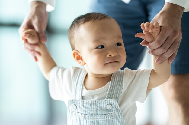 Father's Day concept young Asian father holding a baby child with family person at home happy childhood with love and care together little cute son with dad and parent parenthood lifestyle