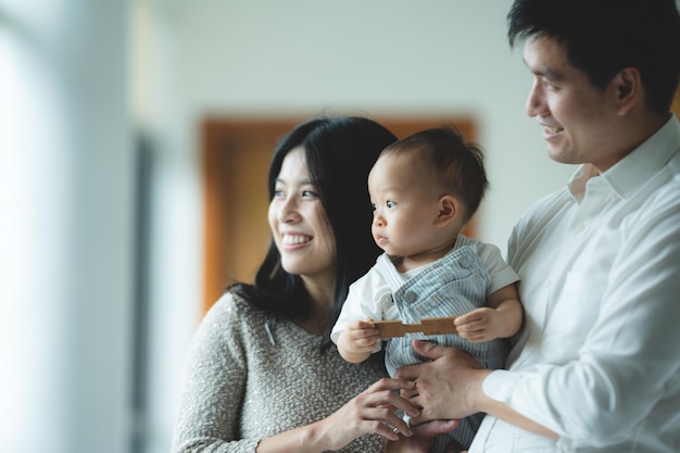 Father's Day concept young Asian father holding a baby child with family person at home happy childhood with love and care together little cute son with dad and parent parenthood lifestyle