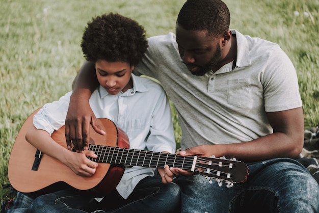 Father Showing Lessons to Play on Guitar to Son