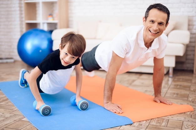 Father and son are engaged in fitness together with fitball.