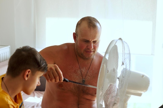 Photo a father and son are repairing an air conditioner to cool the air in the summer heat