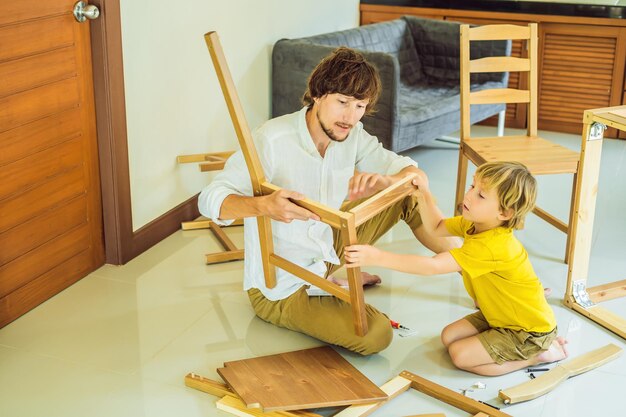 Father and son assembling furniture Boy helping his dad at home Happy Family concept