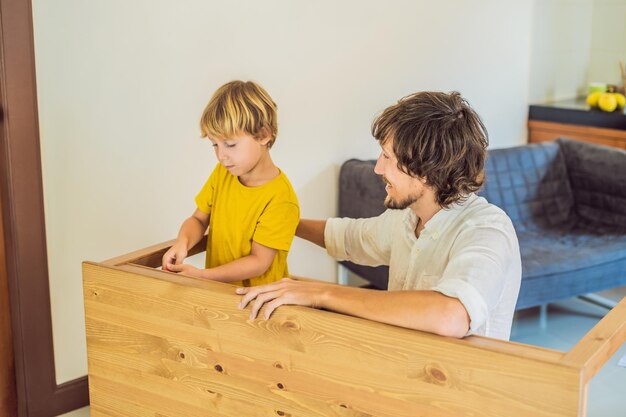 Father and son assembling furniture Boy helping his dad at home Happy Family concept