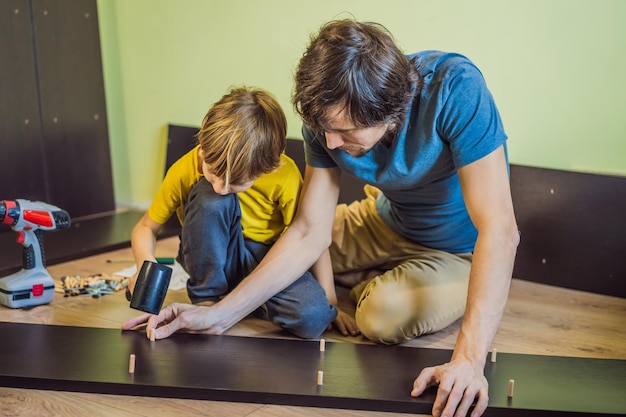 Father and son assembling furniture Boy helping his dad at home Happy Family concept