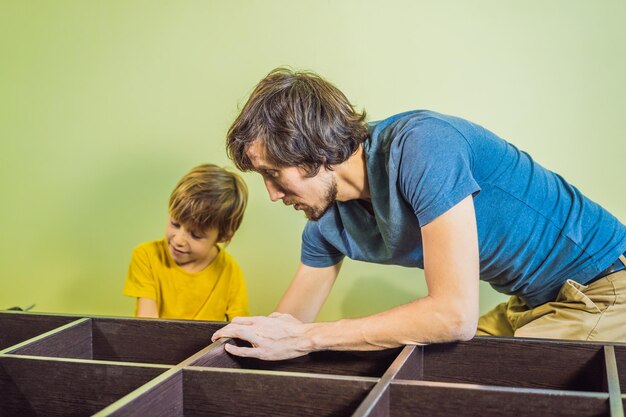 Father and son assembling furniture Boy helping his dad at home Happy Family concept