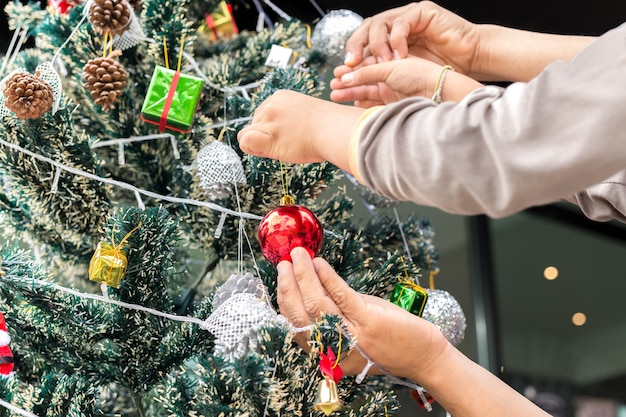 Father and son decorating Christmas tree at home.