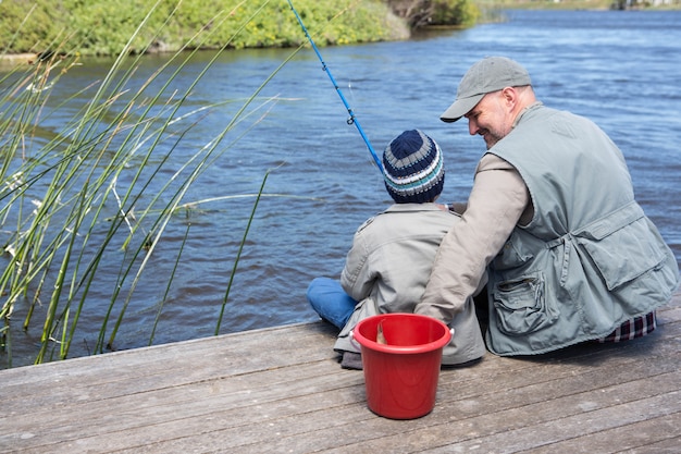 Father and son fihsing at a lake