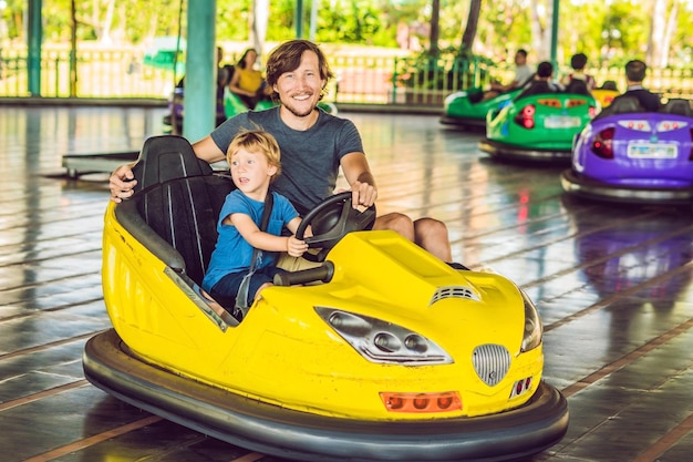 Father and son having a ride in the bumper car at the amusement park