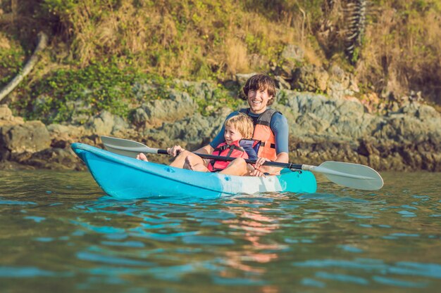 Father and son kayaking at tropical ocean.