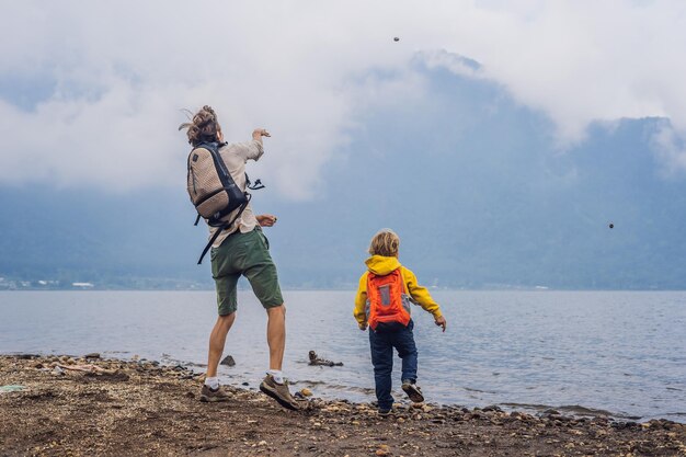 Father and son at the lake bratan and the mountains covered with clouds