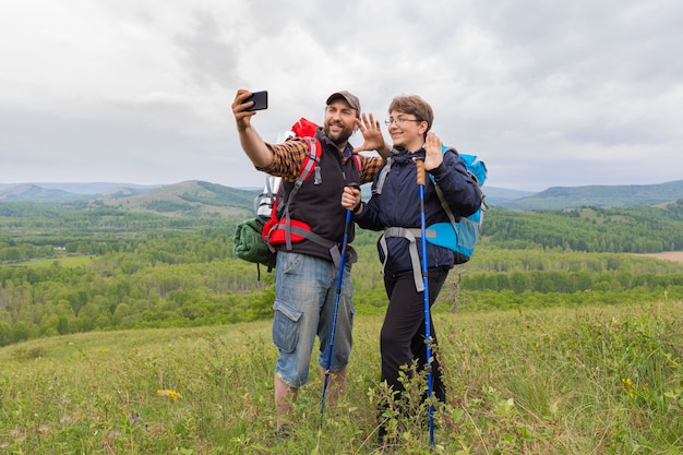 Father and son made a trip selfie on the top of the hill