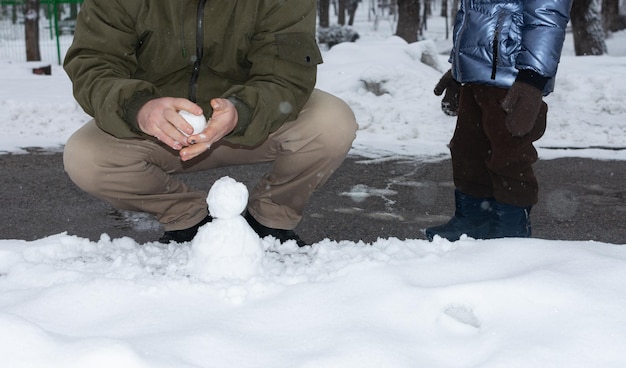 Photo father and son making a snowman