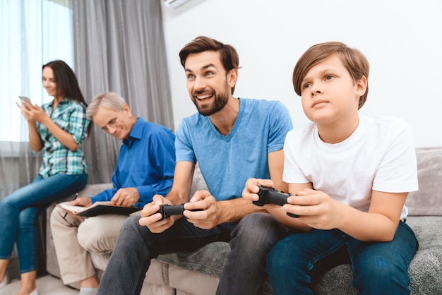 Father and son play game on game console.