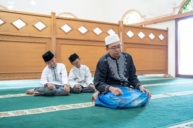 Father and son praying together in the mosque