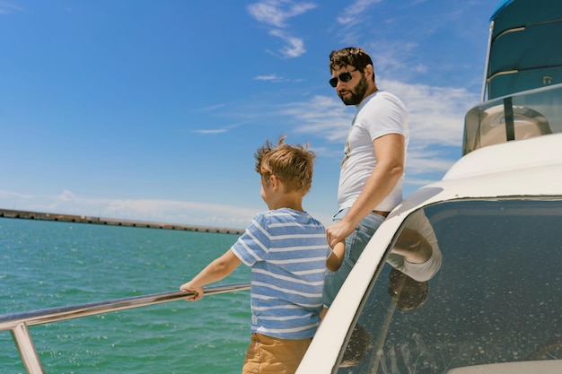 Father and son sailing on yacht enjoying sea view Image with selective focus