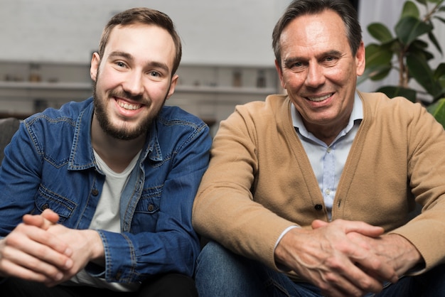 Father and son smiling and posing in living room