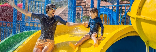 Father and son on a water slide in the water park banner long format