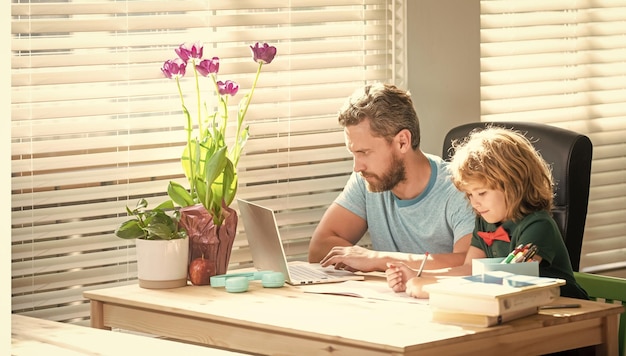 Father and son writing and use computer at home family blog boy do homework