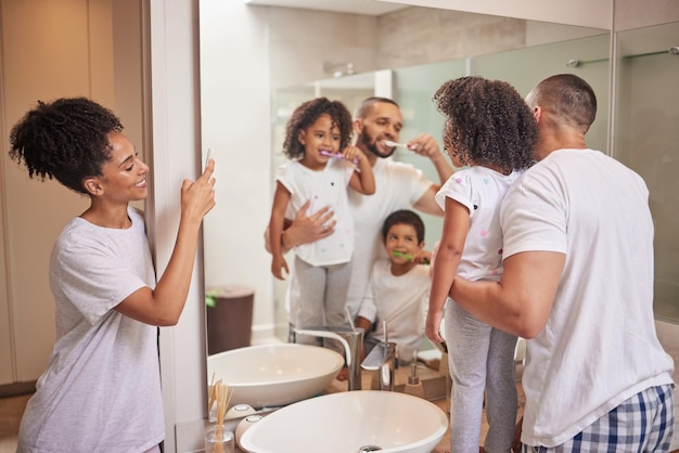 Father teaching kids to brush teeth in bathroom happy mom photograph children learn dental health and morning in miami home Parents clean mouth personal hygiene and photo of family check mirror