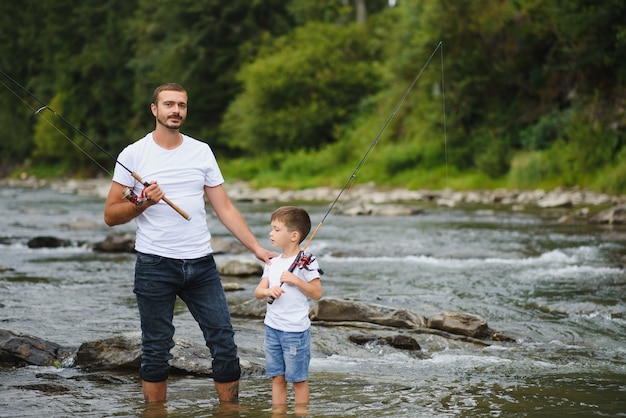 Father teaching son how to fish in the river