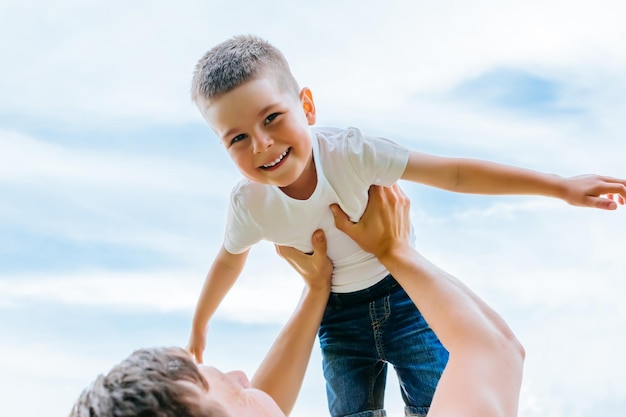 Father throwing his little son up in the air family time together happy little boy having fun with h